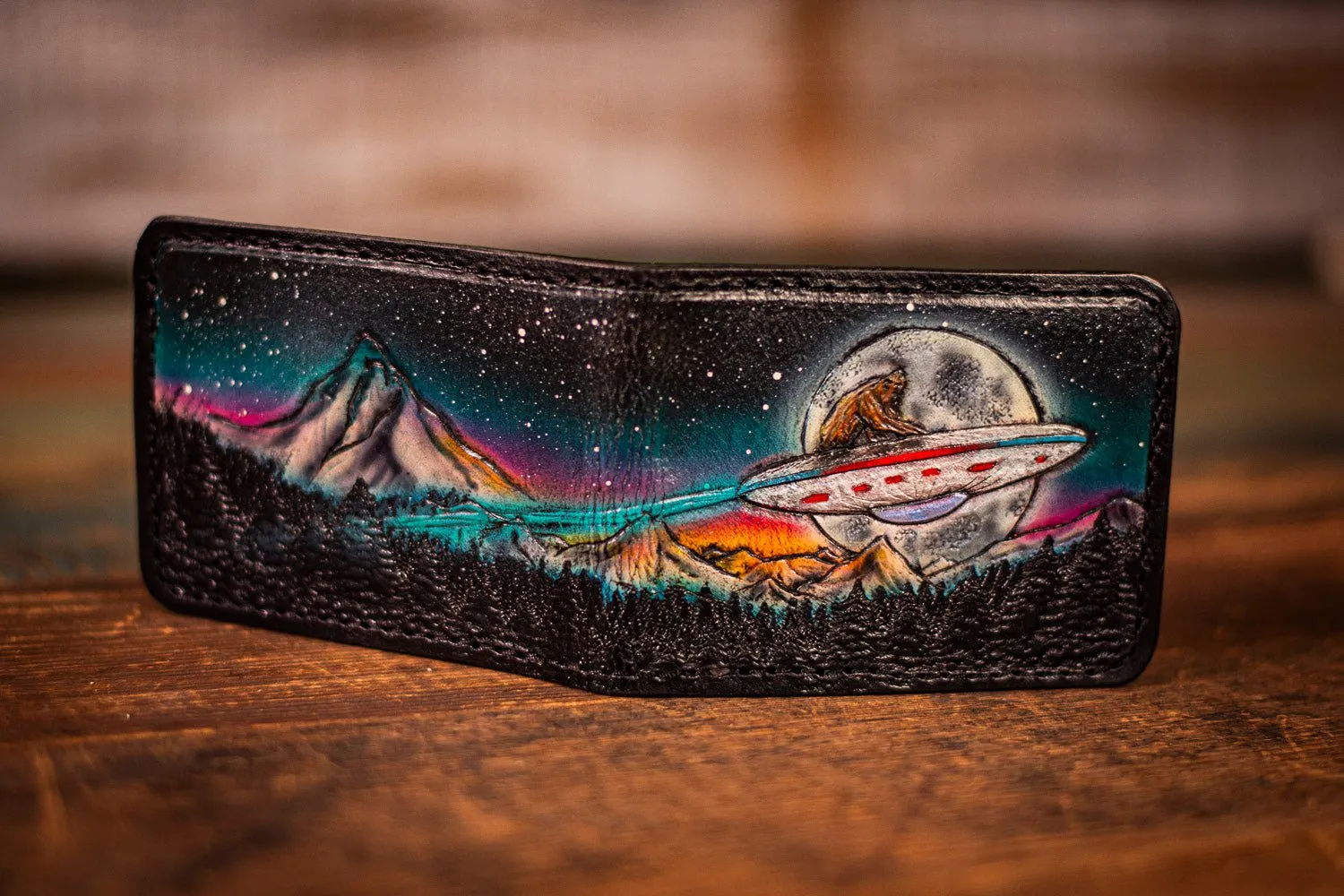 Handcrafted Leather Bifold Wallet - Bigfoot on UFO with Moonlit Mountains and Aurora Borealis - Cryptid and UFO-Inspired Wallet